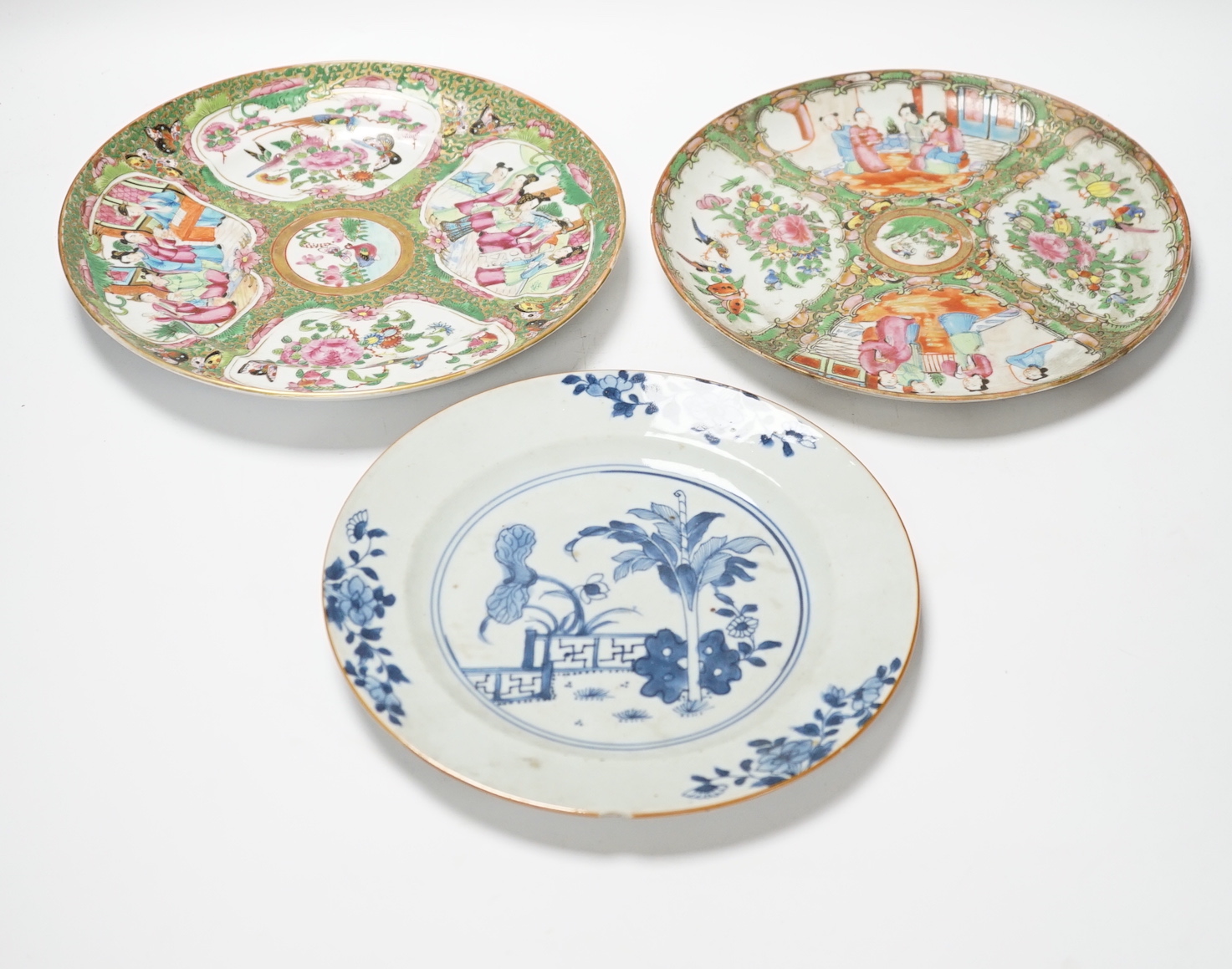 Two 19th century Chinese famille rose plates and an 18th century blue and white plate, 24cm in diameter